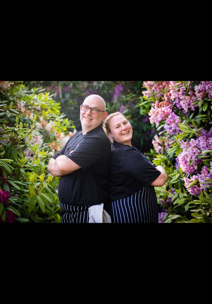 The founders of The Food Consultancy Group, two chartered food safety consultants standing back to back in chef whites